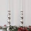 Silver barleytwist candlesticks on mantlepiece with Christmas garland