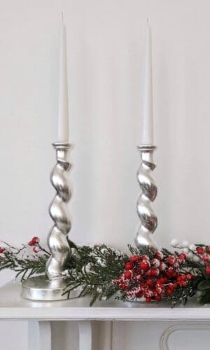 Silver barleytwist candlesticks on mantlepiece with Christmas garland