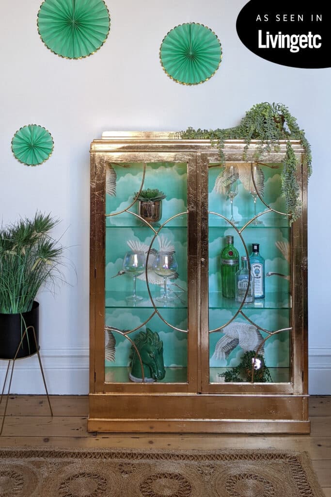 Gilded glass cabinet with green wallpaper