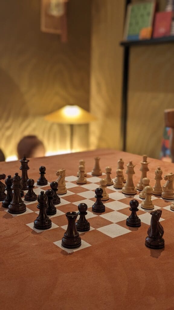 Tan suede chess table with chess pieces