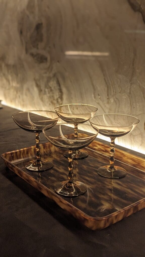 Cocktail glasses on a tortoise shell tray against a marble background