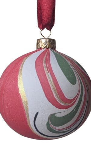 Red, green, black, white and gold marbled ceramic bauble on red satin ribbon