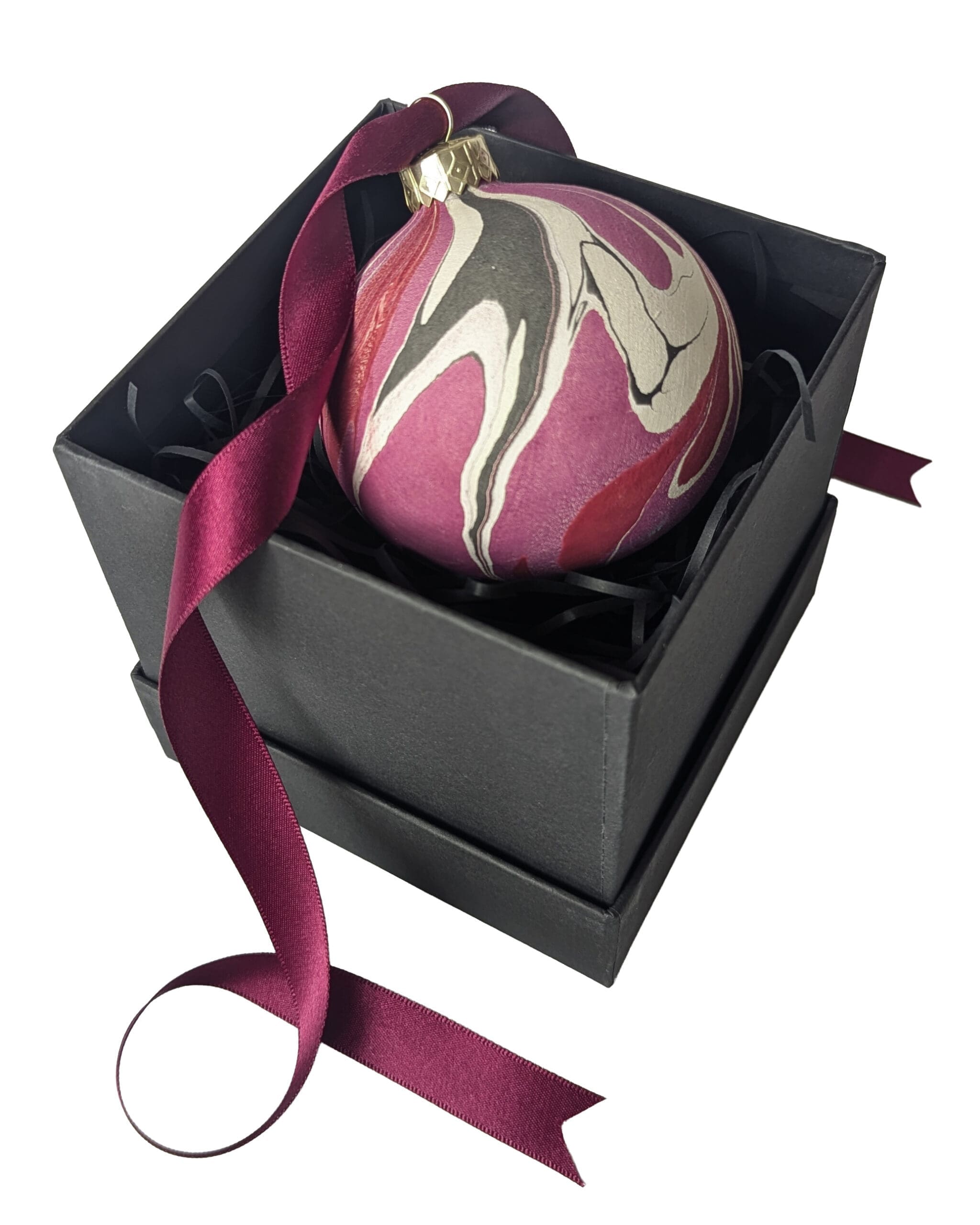 Marbled ceramic Christmas bauble in reds and purples in a black gift box with a curly dark red ribbon