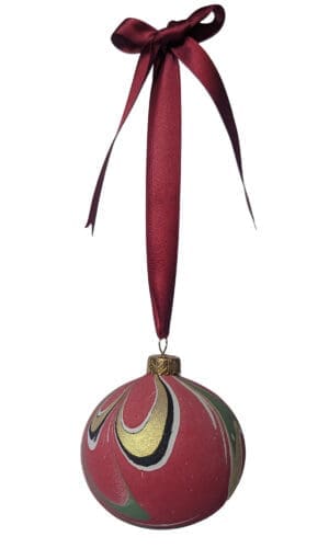 Red, gold and green marbled christmas bauble hanging on red ribbon bow