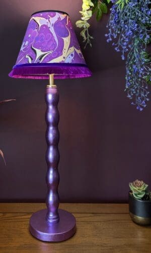 Purple gilded cordless lamp with fringed purple marbled lampshade