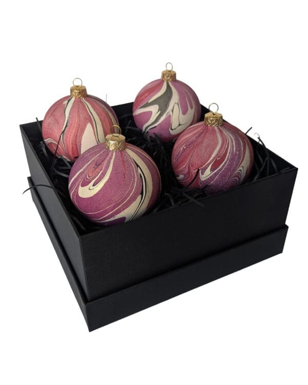 Box of cherry red, plum and gold marbled Christmas baubles in a square black gift box