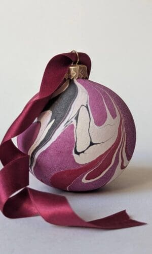 cherry red marbled bauble with dark red trailing ribbon