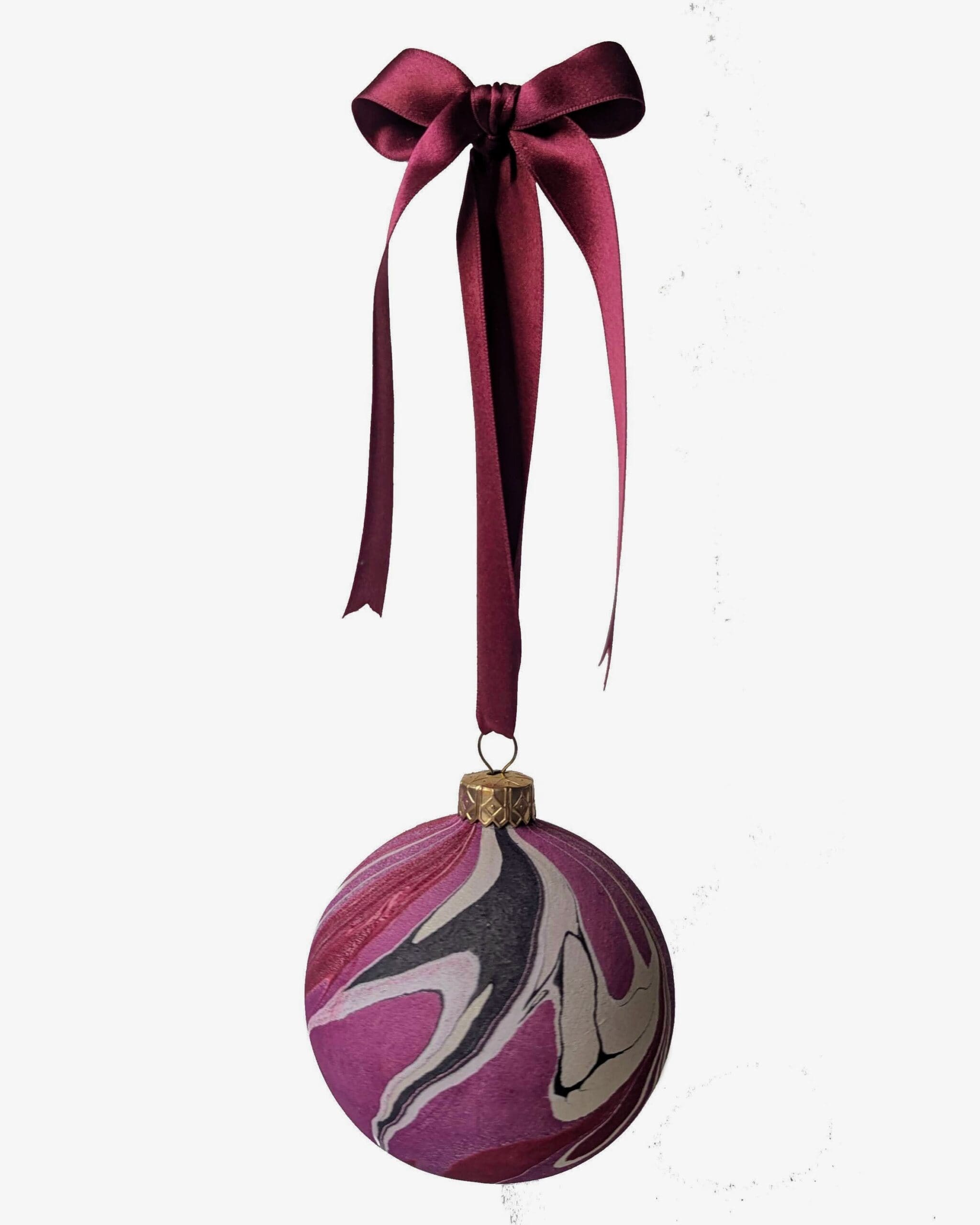 marbled christmas bauble in cherry red, plum, black and gold hanging on dark red satin ribbin with bow