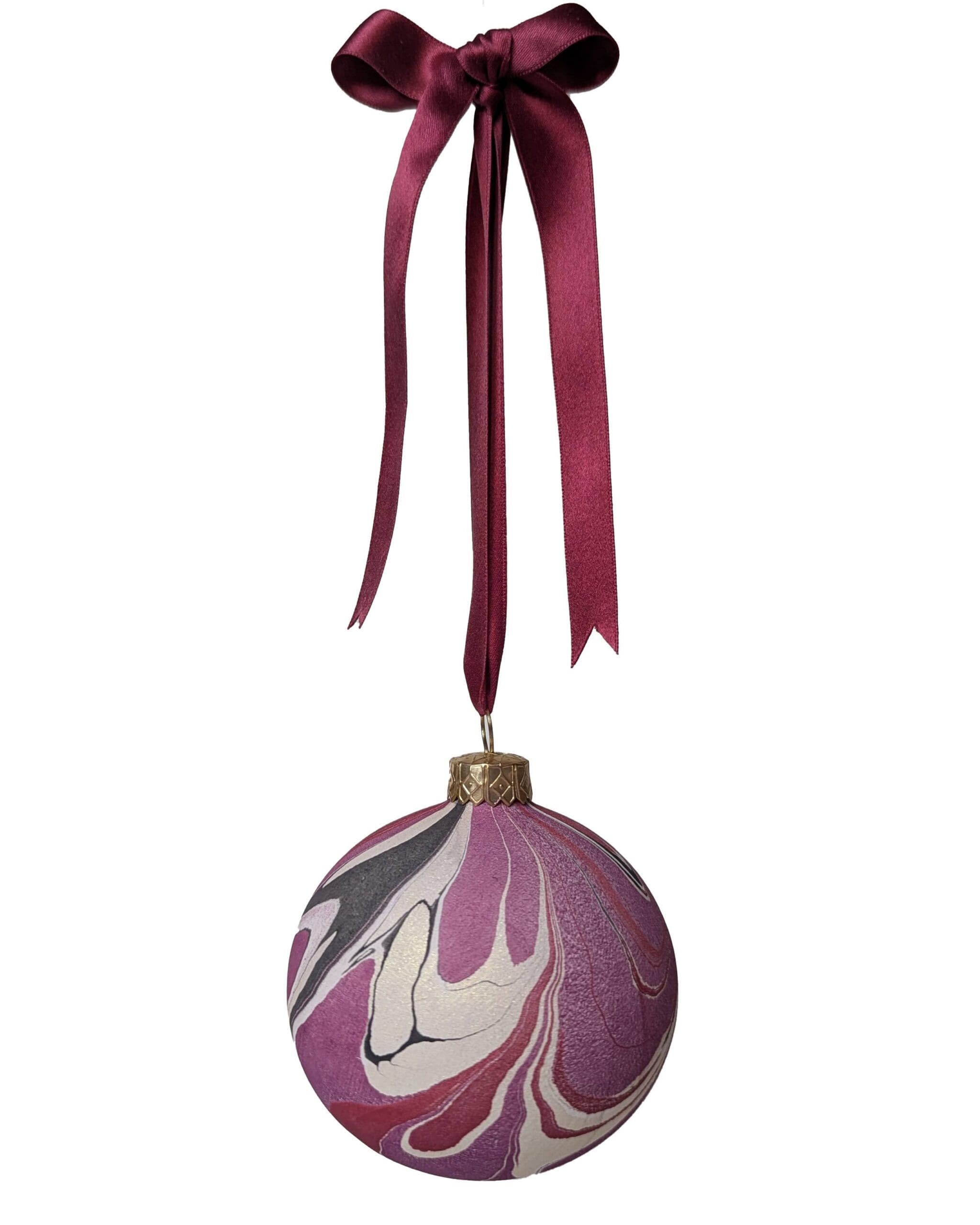 marbled christmas bauble in cherry red, plum, black and gold hanging on dark red satin ribbin with bow