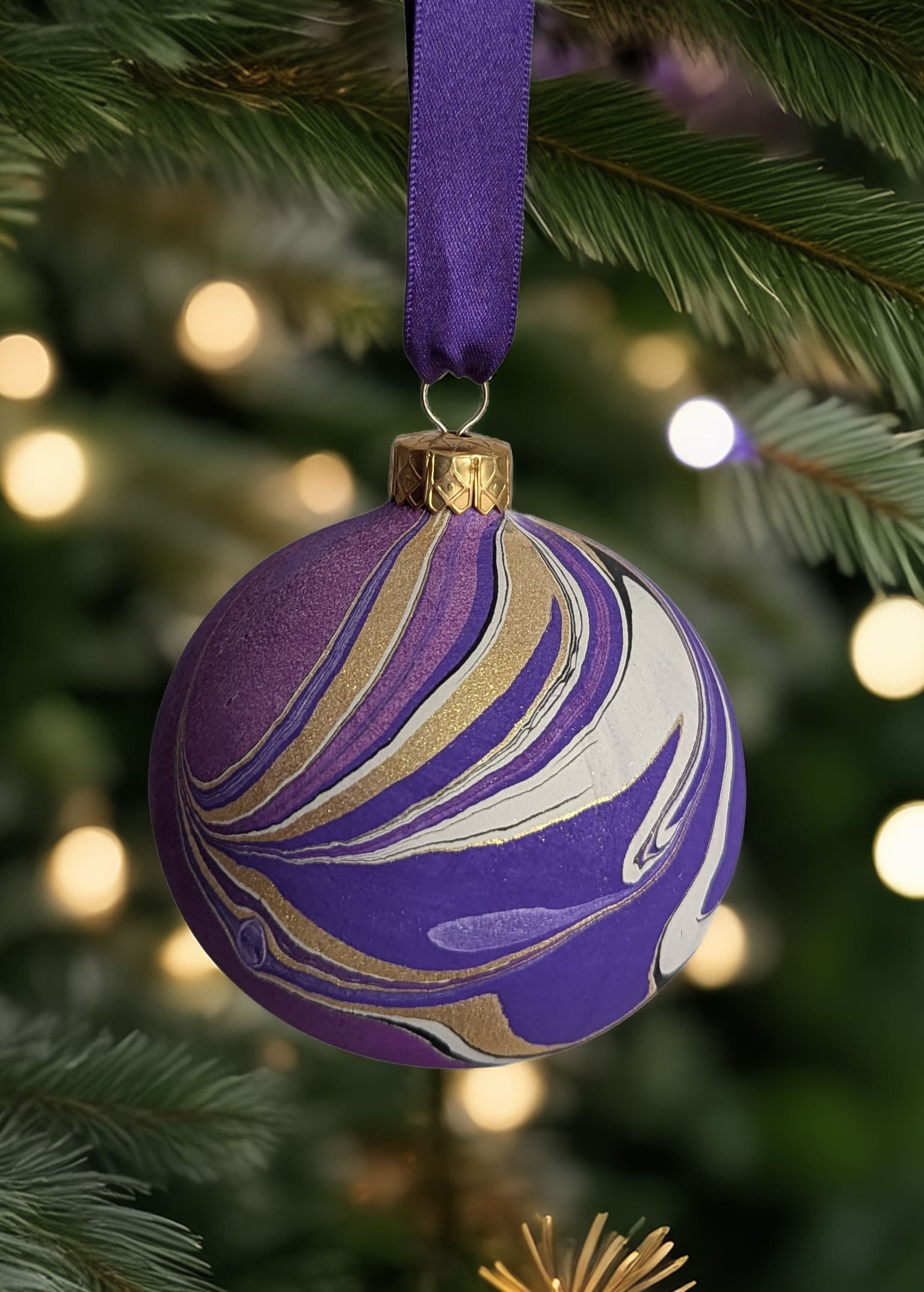 purple marbled Christmas bauble hanging on Christmas tree
